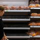 Woman looking at empty grocery store shelves